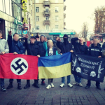 Militanti neonazisti armati con simboli delle SS accanto a una bandiera ucraina sul fronte di guerra